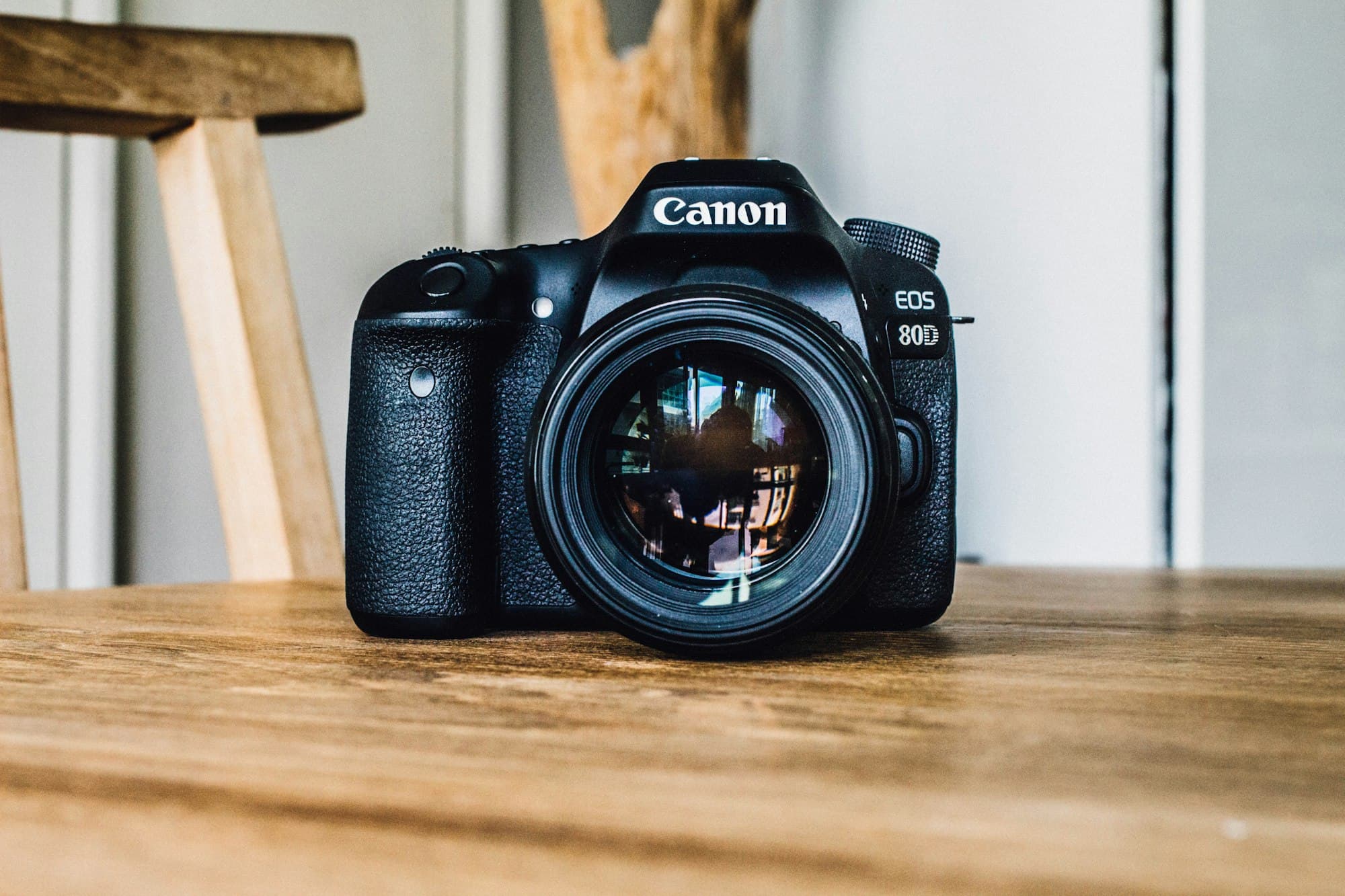 Canon AE-1 camera met zwart 50mm objectief op houten tafel